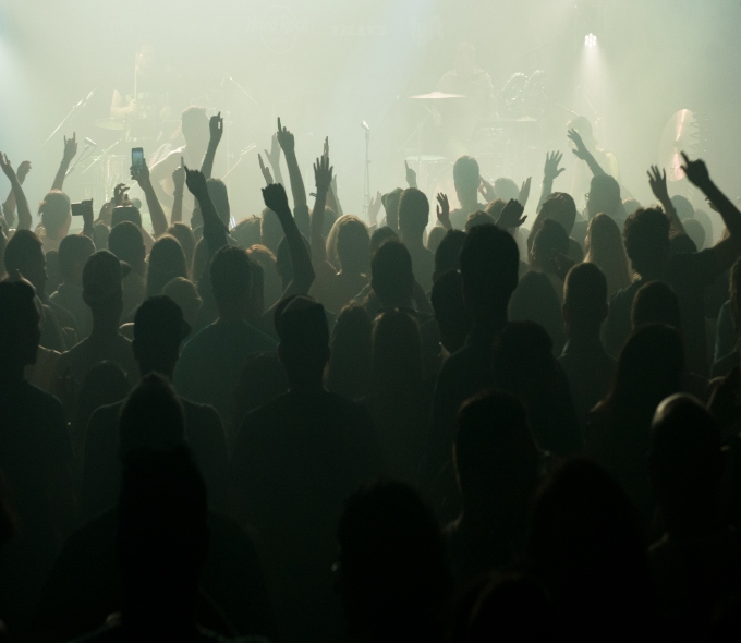 Silhouettes of concertgoers with their hands in the air